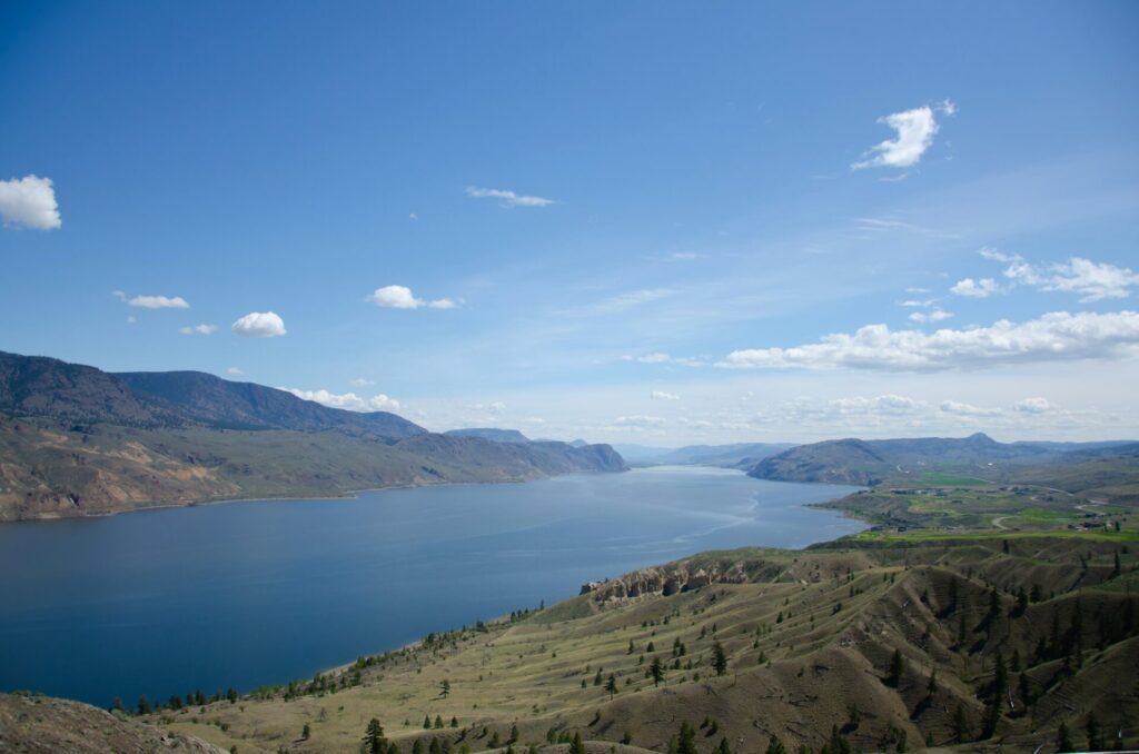 Kamloops Lake surrounded by mountains under the blue sky