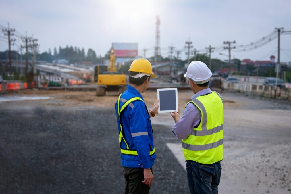 Construction engineer wear safety uniform under inspection and survey workplace by tablet with excav